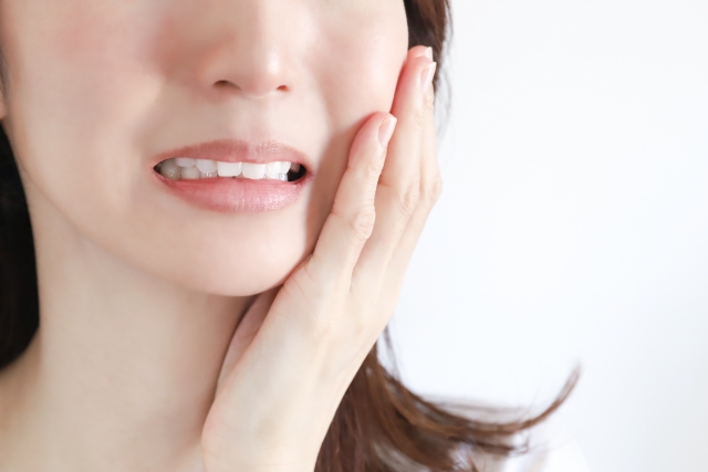 顎を手で押さえる女性